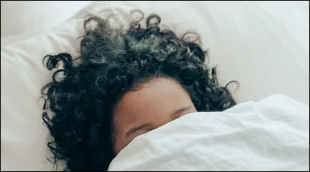 이불을 푹 덮고 자고 있는 여성