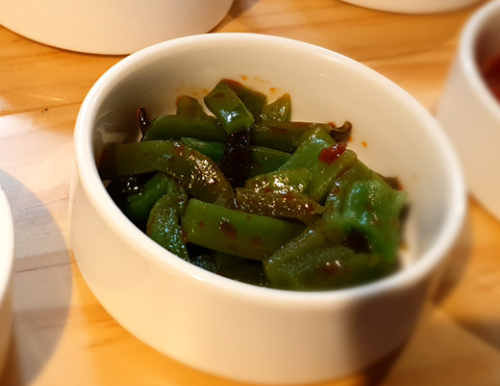 고추기름 넣고 무침한 궁채나물이 하얀 그릇에 담겨 있는 모습