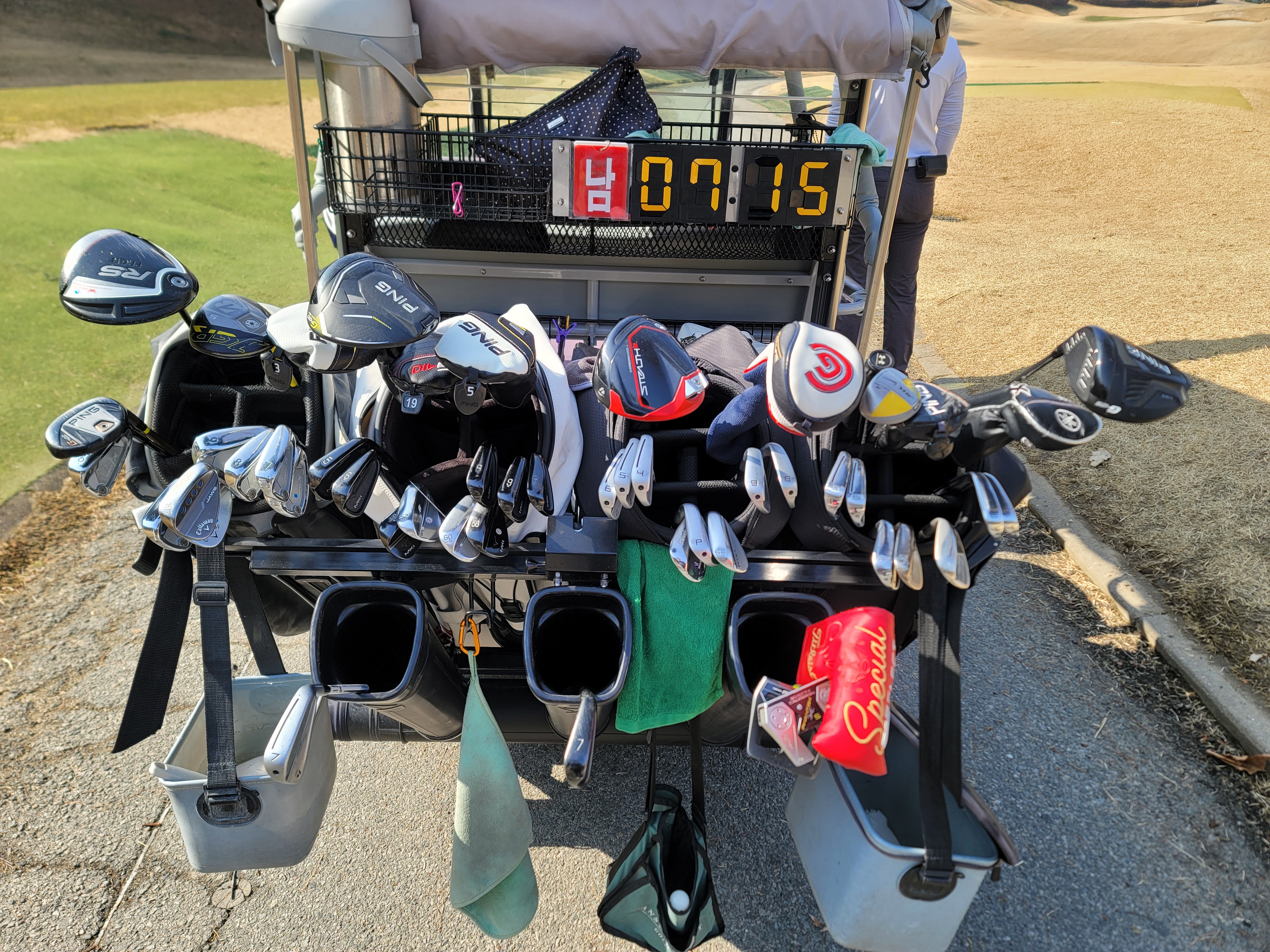 카트에 골프백이 실려있고 골프백에는 클럽이 가득 담겨있는 이미지