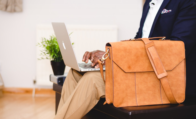 man working on a laptop with work bag