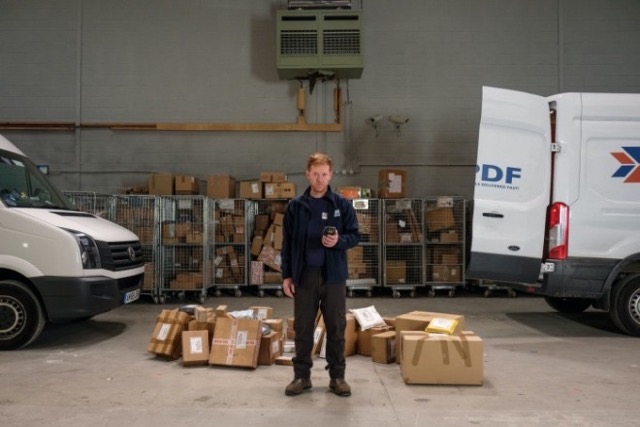 택배 더미 앞에 서 있는 리키 사진