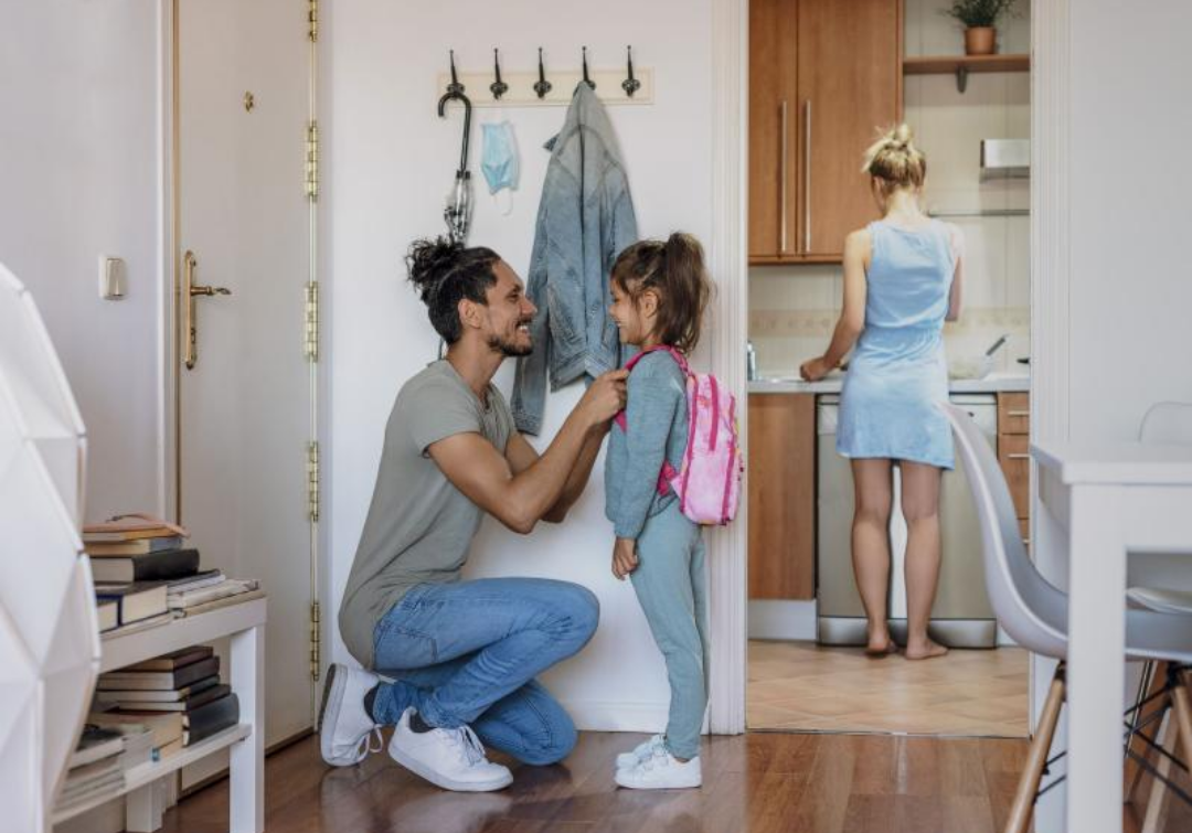 딸의 등교 준비를 아빠가 기뻐하며 도와준다.