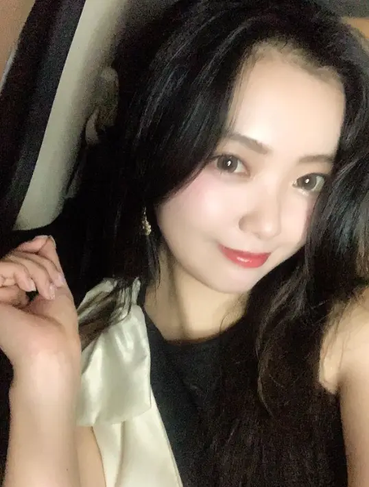 현역가왕- 검은 긴웨이브머리 검정색 민소매 원피스 어께에 아이보리색 리본을 달고 미소지으며 정면을 보고있는 요요미