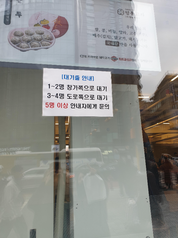 유리창에 부착된 대기줄 안내 문구. 1 ~ 2명과 3 ~ 4명 대기 줄이 다르다.