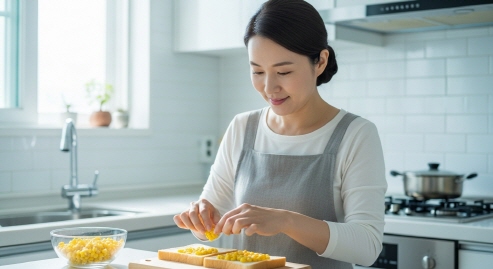 샌드위치를 만들기 위해 초당옥수수를 빵 사이에 넣고 있는 주부의 모습