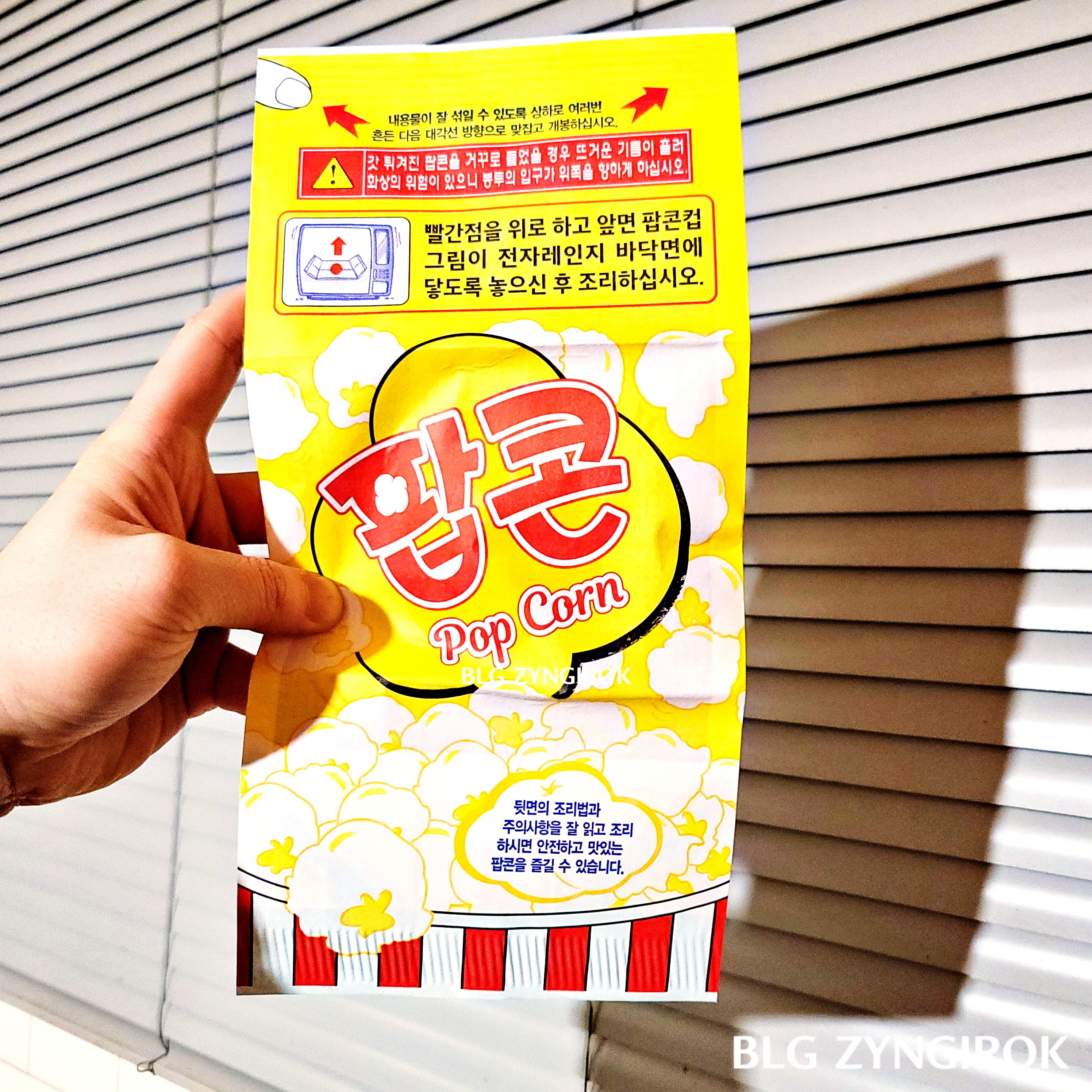 편친 노브랜드 팝콘 봉투를 들고있다.