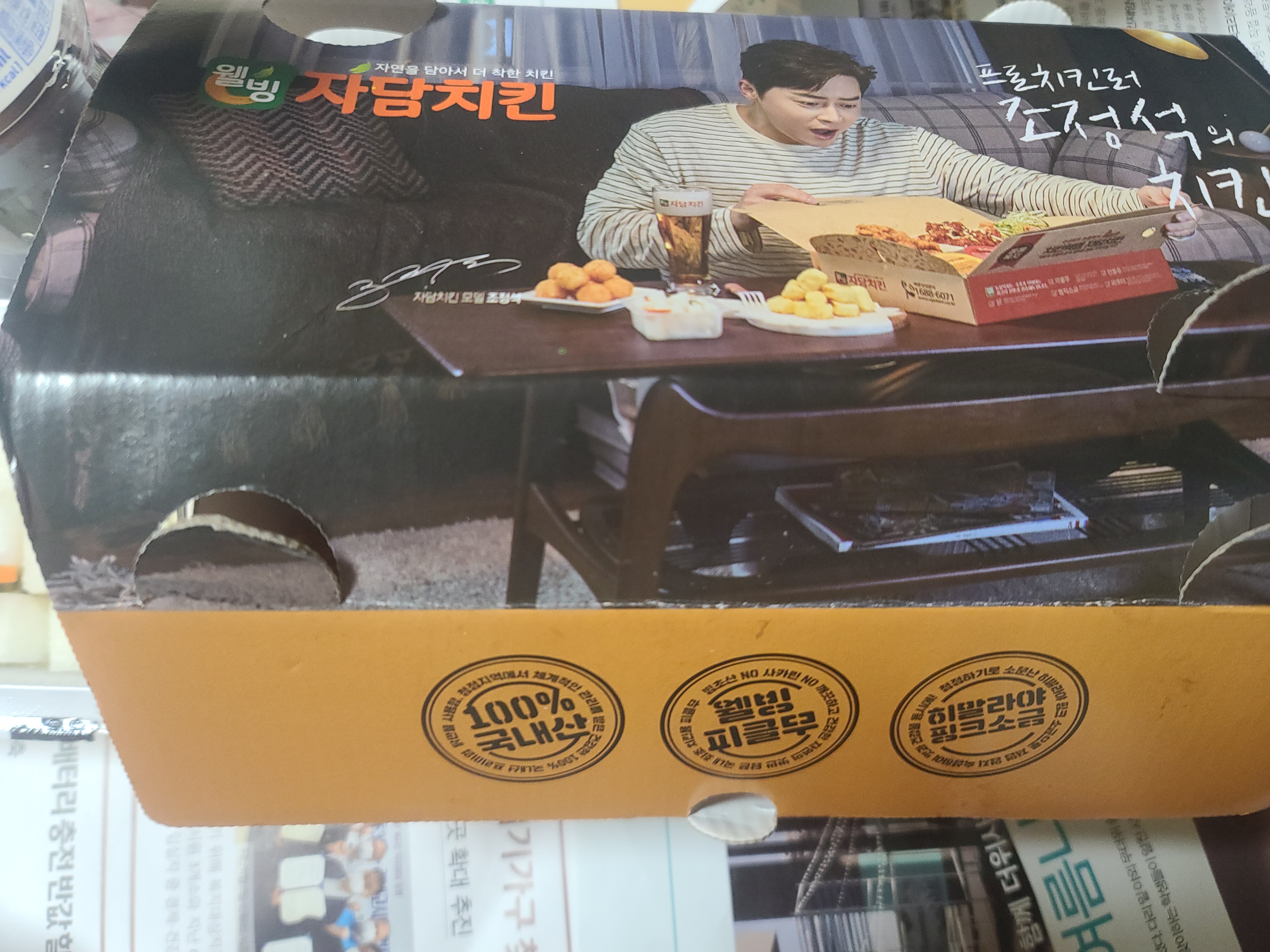 자담치킨 포장박스 모습. 배우 조정석이 있는 치킨 상자