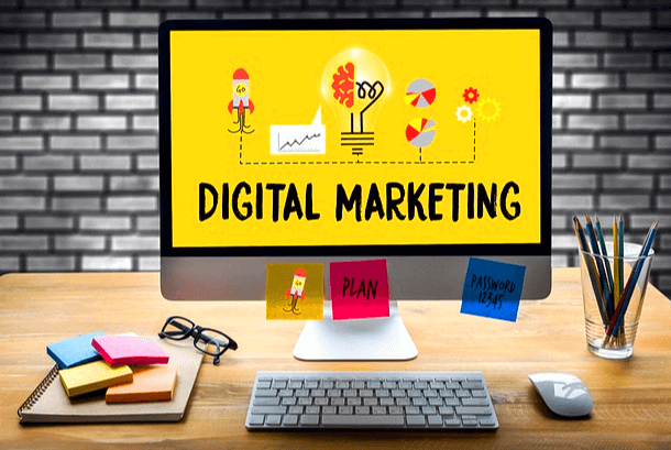 책상 위에 커다란 PC가 있다. 노란 화면에 영문자로 디지털 마케팅이 쓰여졌다.