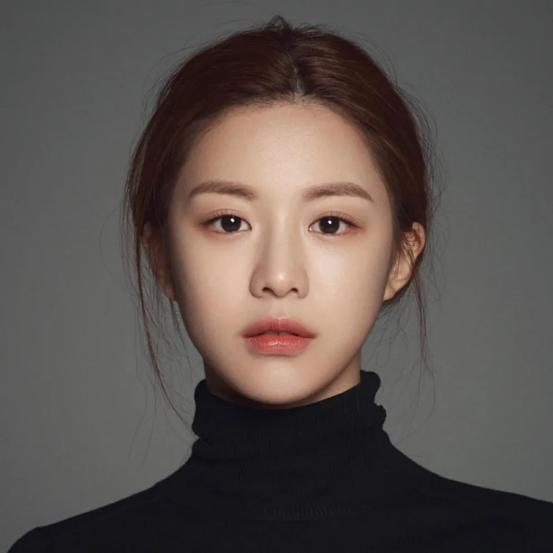 회색 배경에 갈색 머리를 말아 올리고 검은 목티를 입은 배우 고윤정