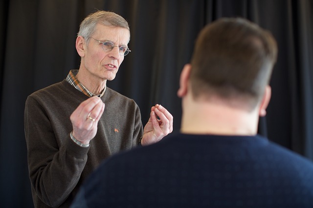 60대의 남성이 다른 성인 남성을 향해 강의하고 있음.