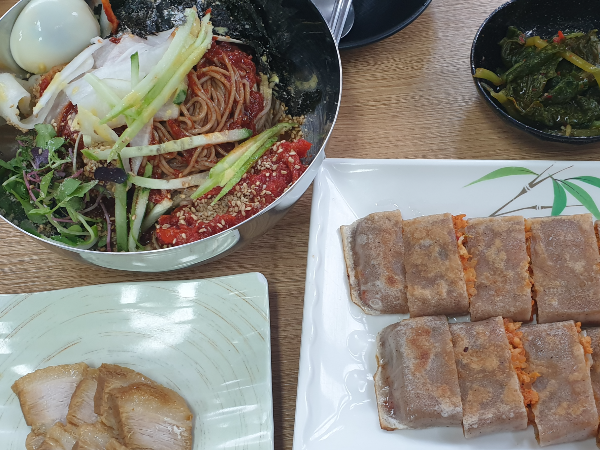 메밀 전병과 비빔막국수 그리고 서비스로 나온 수육이 보인다.