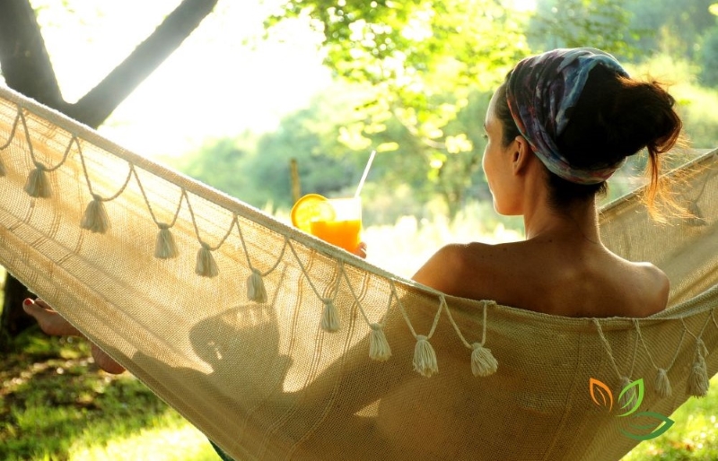 여름 그늘에서 해먹에 누워 오렌지 주스를 마시며 휴식하는 여성, 면역력 관리 via canva