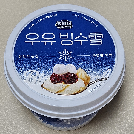 찰떡 우유 빙수 설 포장 사진. 파란색 포장 가운데 빙수를 숟가락으로 뜬 모습이 있다.