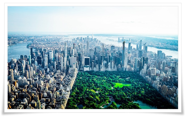 뉴욕 맨해튼의 빽빽하게 들어선 마천루들 사이에 초록빛으로 펼쳐진 넓은 숲과 호수의 모습을 담은 항공사진