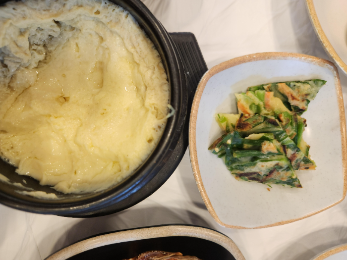 계란찜과 작게 잘린 파전이 테이블 위에 있다