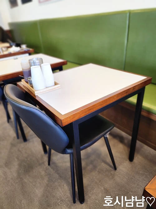 명인대동양평해장국 테이블 – 깔끔하게 정돈된 2인 좌석과 푸른 벽면 좌석