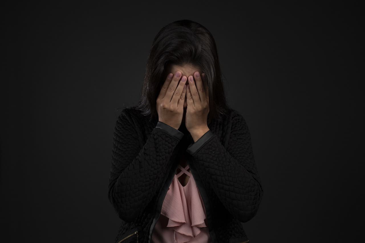 양손으로 얼굴을 가리고 있는 여자
