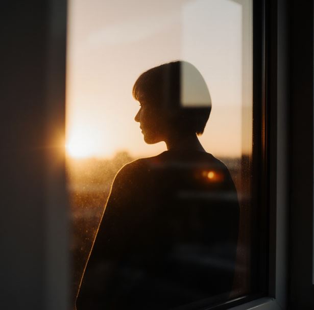 창문에 비친 자신의 실루엣으로 창 밖에는 일출이 비치고 있다.