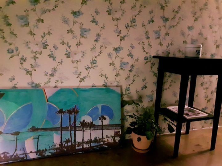 바닥에는-그림이-그려져있는-큰그림액자가-놓여-있고-그옆에는-소품이-올려져있는-테이블이있는-사진