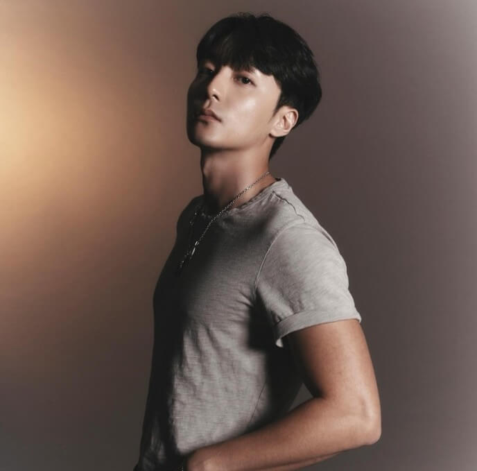 로이킴이-회색-빛-반팔-티를-입고-옆으로-선-채-고개는-앞으로-돌려-정면을-응시하고-있는-사진
