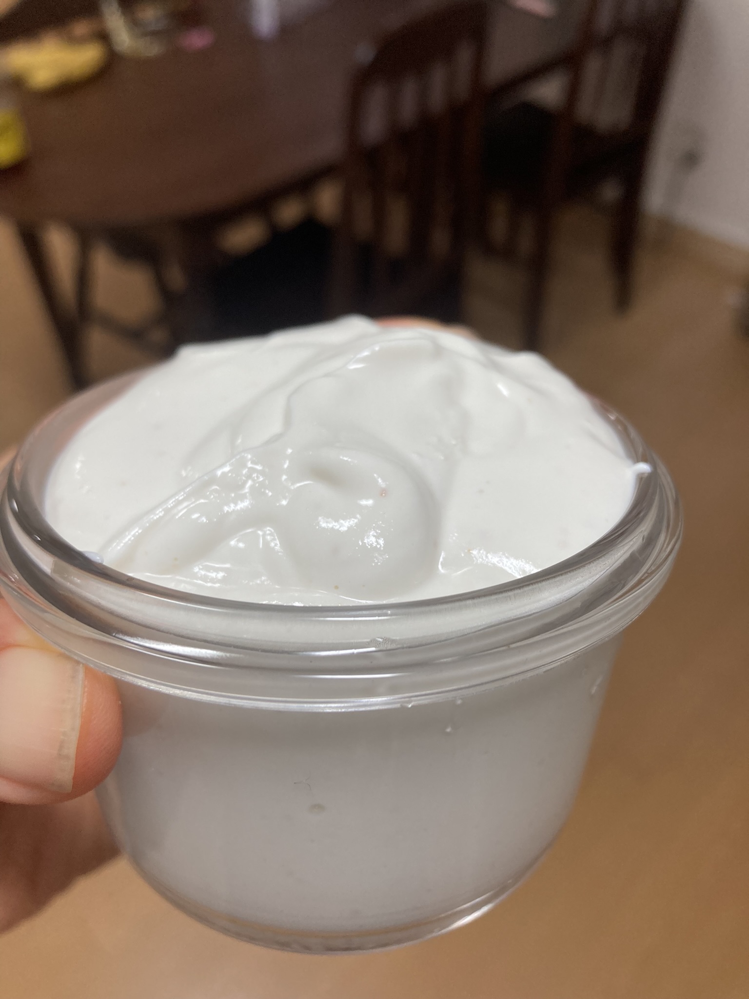 작은 유리 용기에 담긴 신선한 홈메이드 크림치즈. 윤기 있고 꾸덕한 질감이 특징.