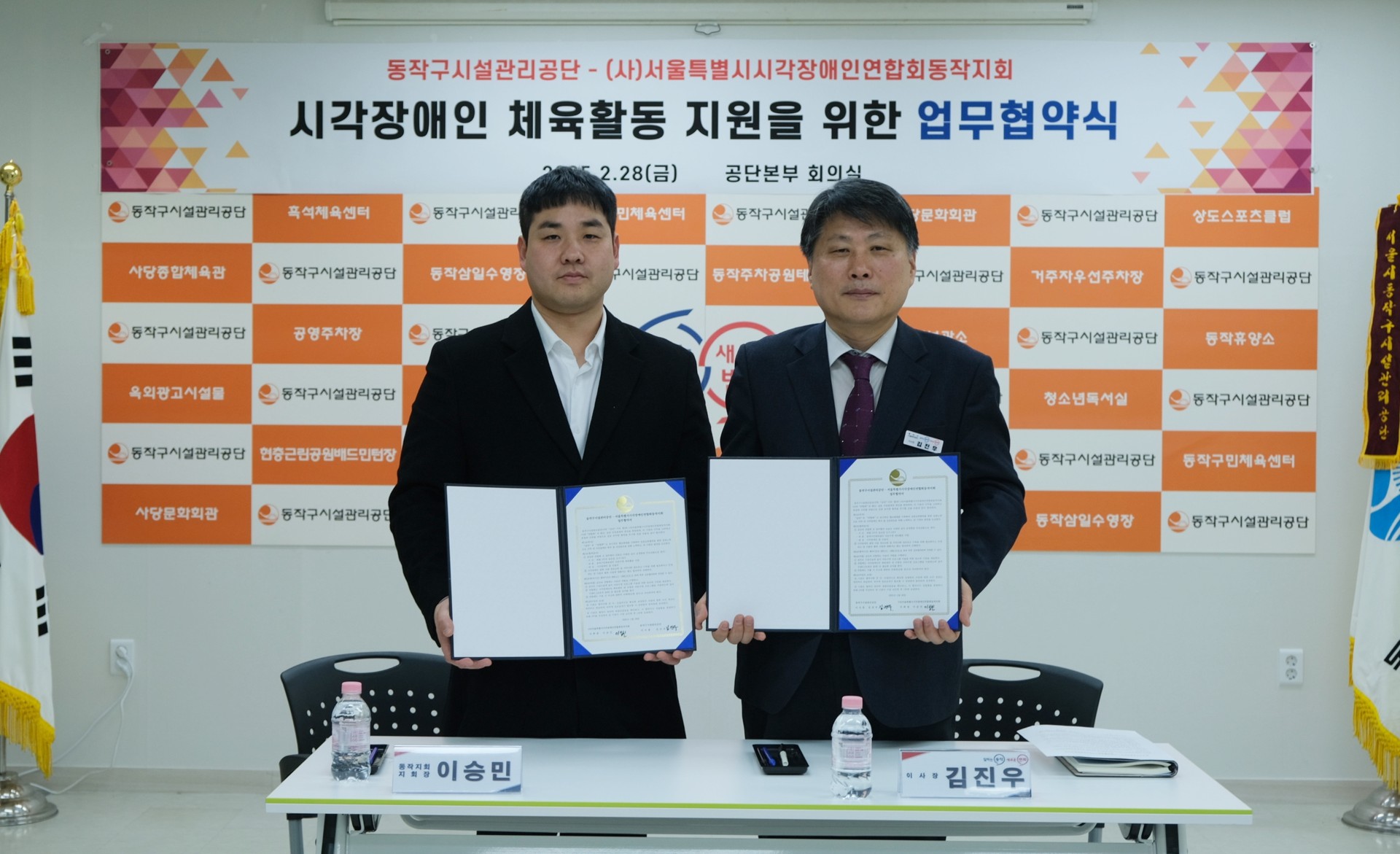 이미지설명: 업무협약을 체결하고 동작구시설관리공단 김진우 이사장과 동작지회 이승민지회장이 업무협약서를 들고 서있다.