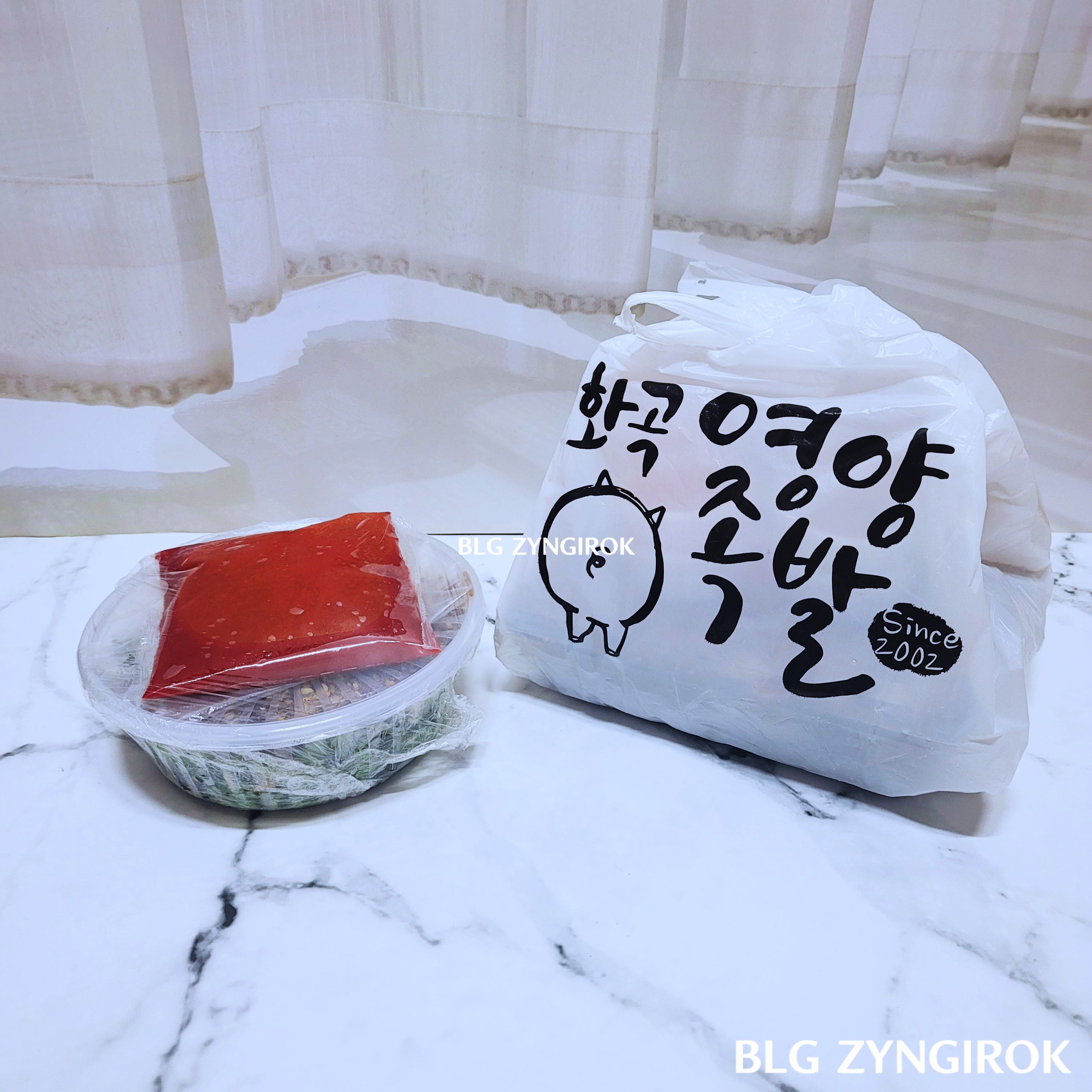 포장해온-화곡영양족발이-놓여있다. 왼편에-막국수-오른편에-족발이-담겨있는-봉투가-놓여있다.