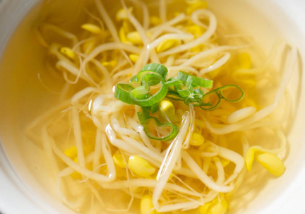 맑은 국물에 콩나물을 넣고 양념을 최소화 해서 끓인 시원한 콩나물국. 그릇에 담고 파로 장식했다.