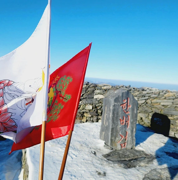 빨간색 하얀색 깃발 산 정산에 꼽은 장면