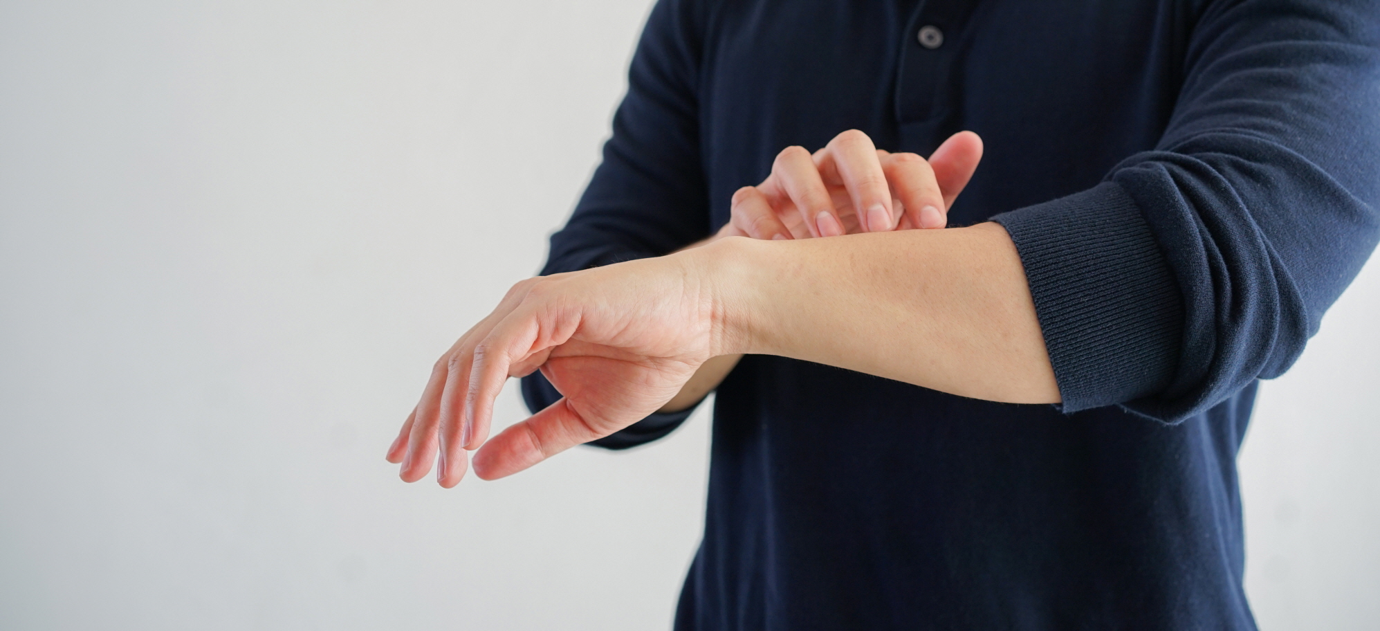 피부가 간지러워 팔을 긁는 사람