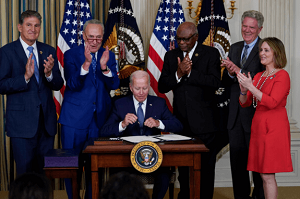 조 바이든이 IRA 법안에 서명하고 있다.
