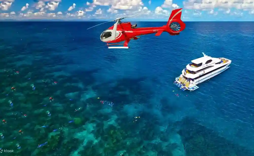 호주 그레이트 배리어 리프 상공에서 비행하는 헬리콥터와 아래에서 스노클링 및 다이빙을 즐기는 크루즈 요트