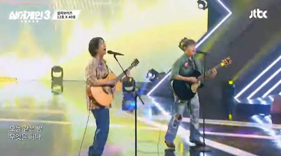 싱어게인3-
초록색 셔츠에 찢어진 청바지 검정색 기타를 들고 스탠딩마이크에 대고 노래하는 40호와 청바지에 격자무늬 셔츠를 입고 노란색 기타를 들고 스탠딩마이크에 노래하는 12호