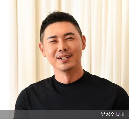 유정수 대표가 검은 티를 입고 미소 짓고 있는 모습