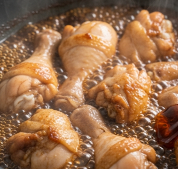 노릇하게 볶아진 닭봉 위에 간장&amp;#44; 설탕&amp;#44; 물 등이 들어간 소스를 붓고 자작하게 끓이고 있는 모습