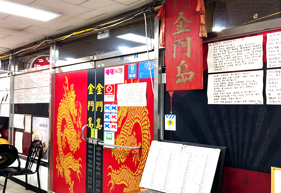 벽면에 각종 안내 문구들이 붙어있고, 문 앞에 예약자 명단이 놓여 있는 전현무게획2 강화도 중국집 금문도 입구