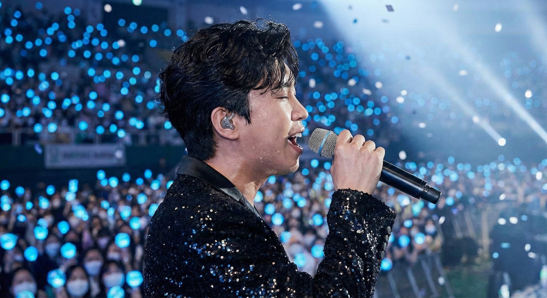 대형 콘서트에서 객석을 가득 채운 파란 응원봉과 라이브 무대 현장감