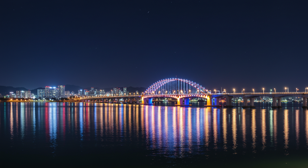 서귀포 새섬 다리와 시내 야경이 조명으로 빛나는 모습