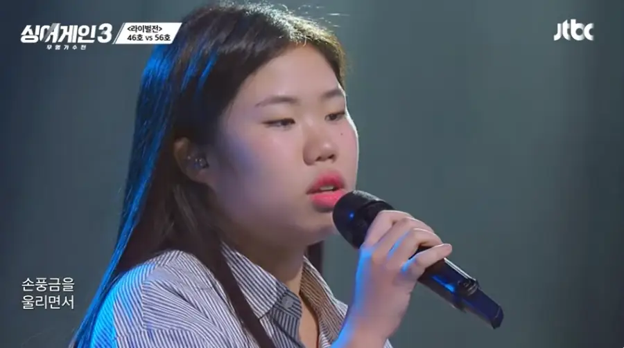 싱어게인3-
회색 무대배경 파란 줄무늬셔츠 검은 마이크를 들고 긴머리를 풀어헤친채 그윽히 눈을 뜨고 노래하는 46호