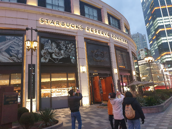 어둑해진 하늘과 조명이 들어온 스타벅스 건물&amp;#44;. 사람들이 사진찍기 바쁘다.