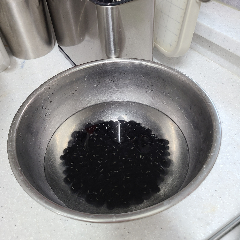 물에 불린 검은콩이 담긴 스테인리스 볼