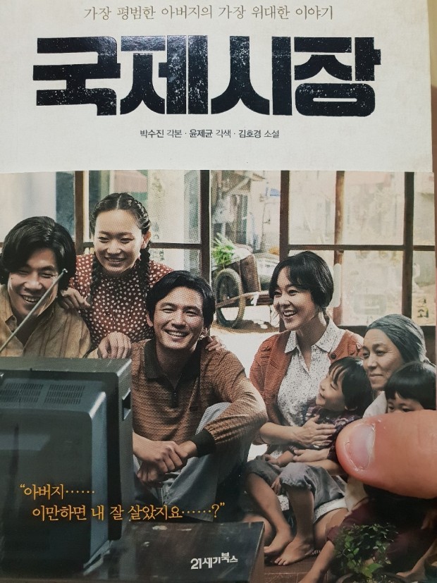 “국제시장” 영화 포스터 – 가족들이 함께 텔레비전을 보며 웃고 있는 따뜻한 장면. 하단에는 ‘아버지… 이만하면 내 잘 살았지요…?’라는 감동적인 문구가 적혀 있다.