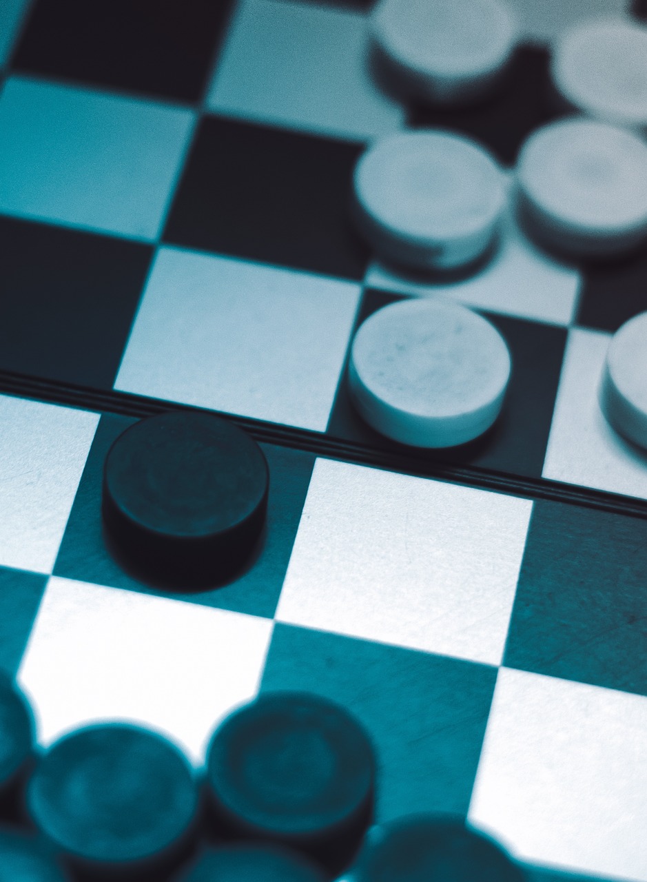 체스보드 위 검은 돌과 흰 돌의 사진