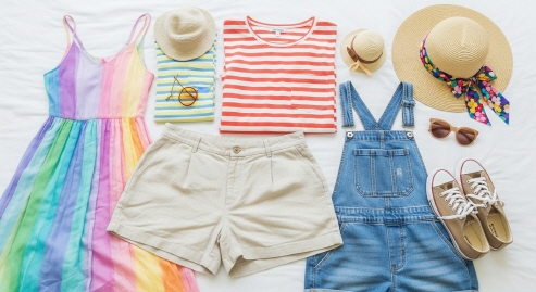 흰 침구 위 여름 옷과 모자, 안경