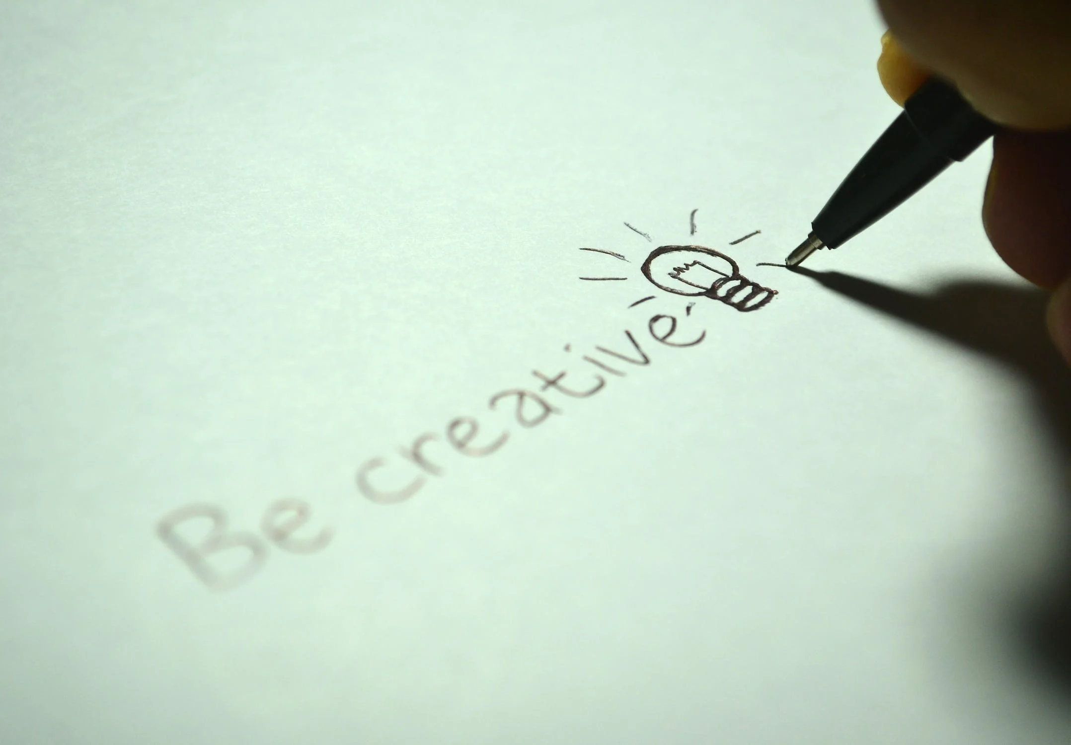 종이에 펜으로 be creative라고 적고 있다.