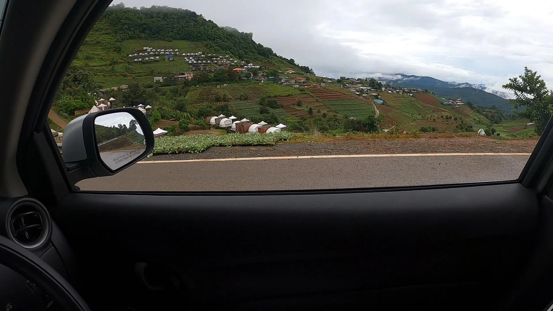 차 안에서 바라본 몬잼 고산지대의 테라스형 계단식 농장과 글램핑장 전경
