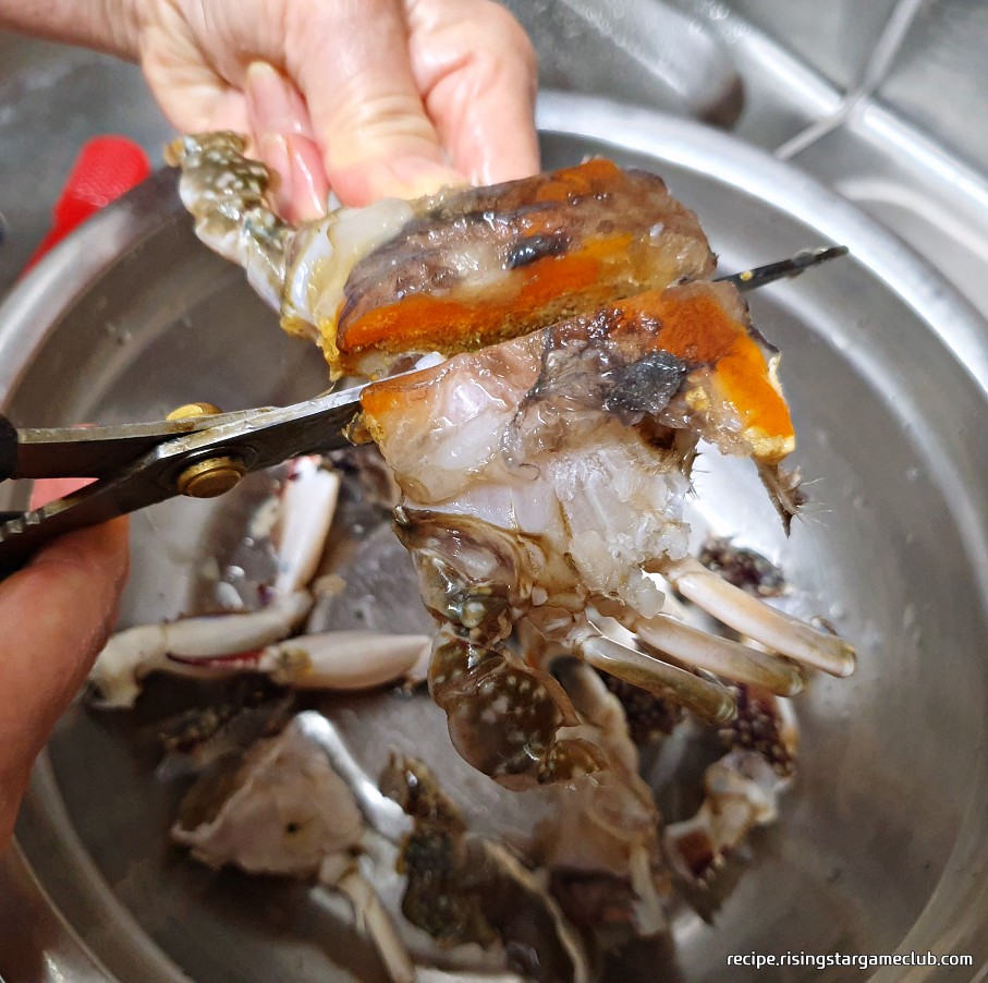 맛있는 양념게장에 들어갈 꽃게의 몸통을 가위를 이용해 반으로 자르는 사진