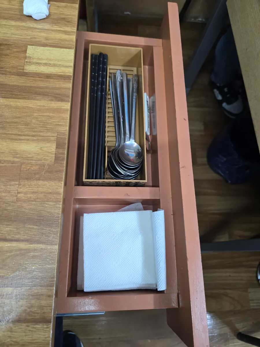 수저통에 숟가락과 젓가락,휴지가 놓여있는 모습