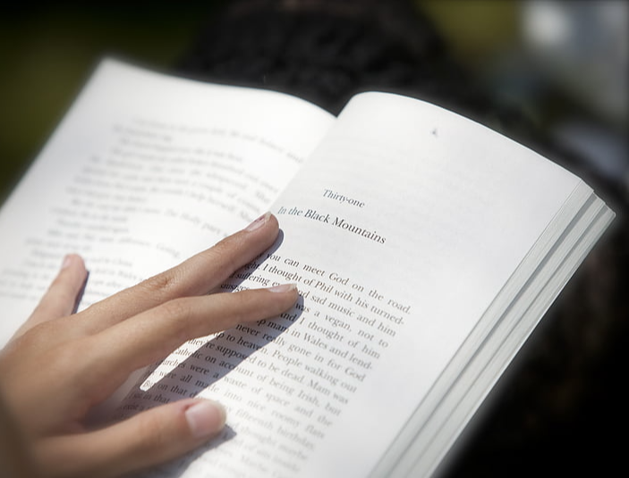 펼친-책-위에-손을-얹고-책을-봄