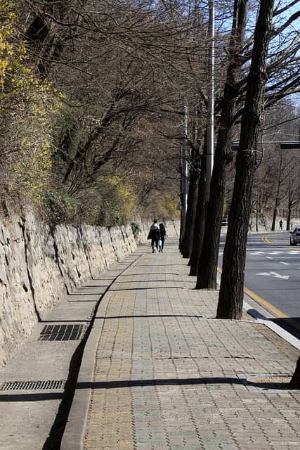 인도위를 걷는 마스크를 쓴 사람들